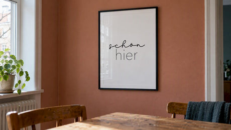 Poster im Rahmen an einer Wand in Terrakottafarbe
